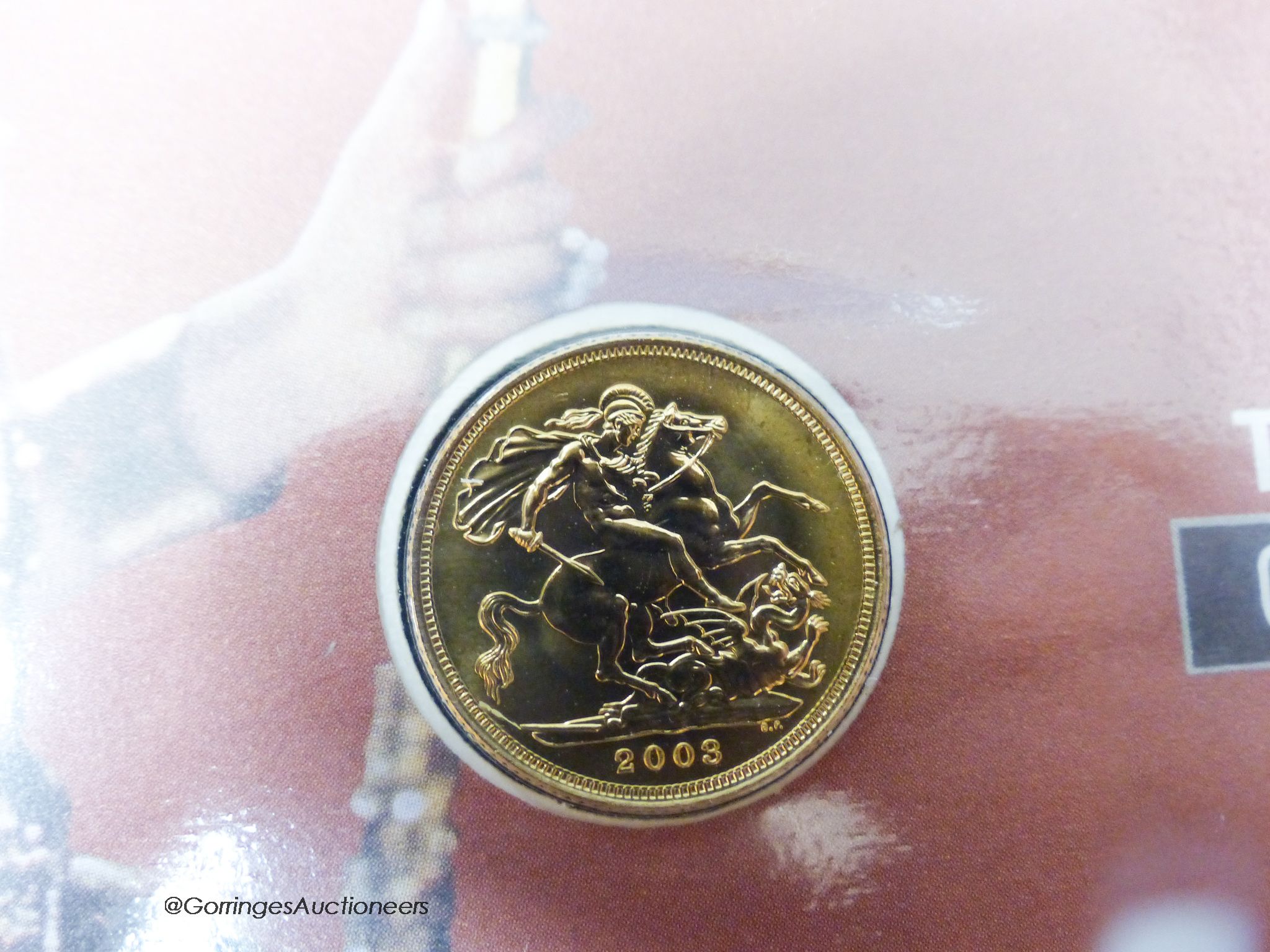 A 2003 gold bullion sovereign presented in a Coronation Jubilee cover, with certificate of authenticity.